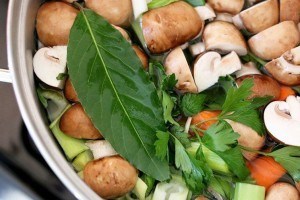 bowl of vegetable stock with mushrooms carrots leeks herbs