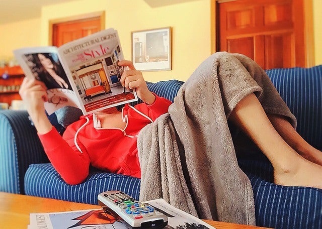 Woman sitting on the couch reading a magazine