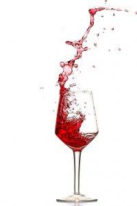 Red wine splashing out of glass