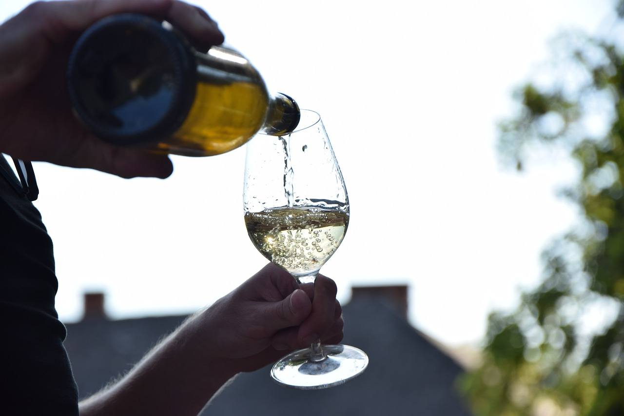 White wine being poured into a glass from a bottle