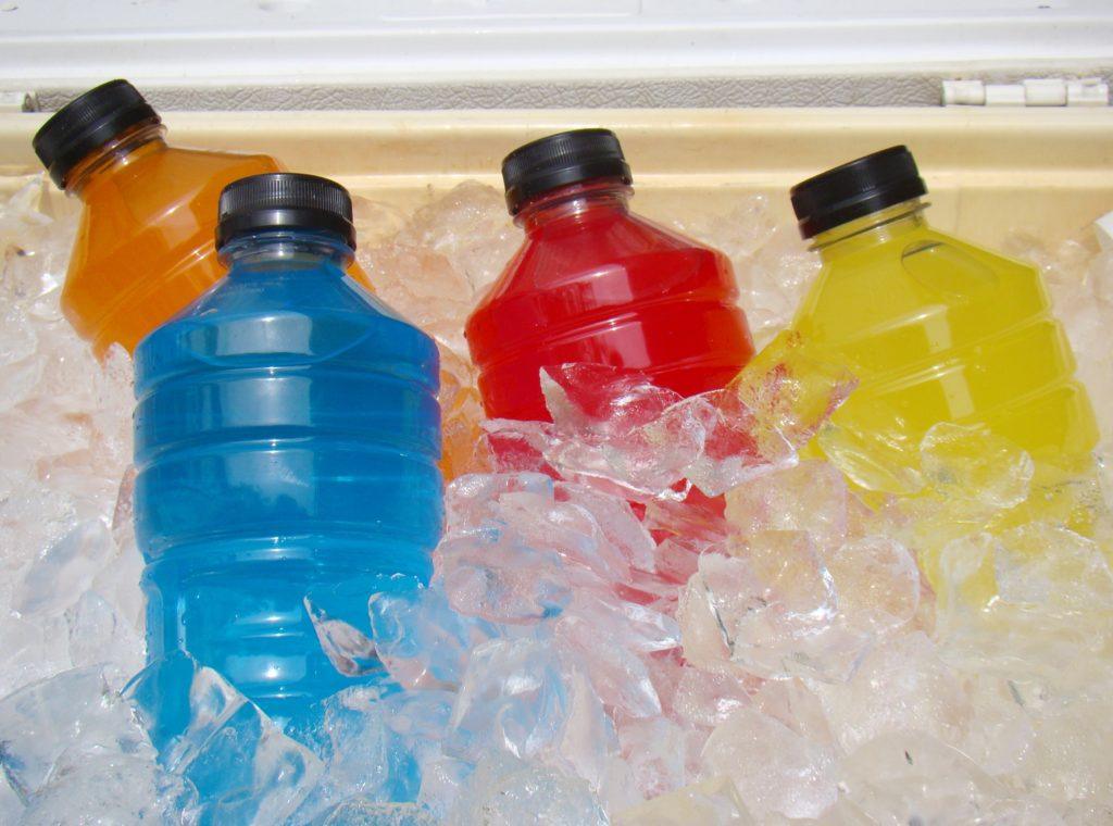 blue, orange, red, and yellow colored sports drinks on ice