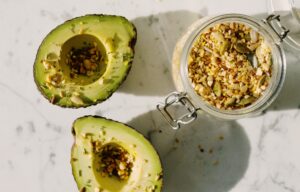 avocado halves sprinkled with seeds and nuts
