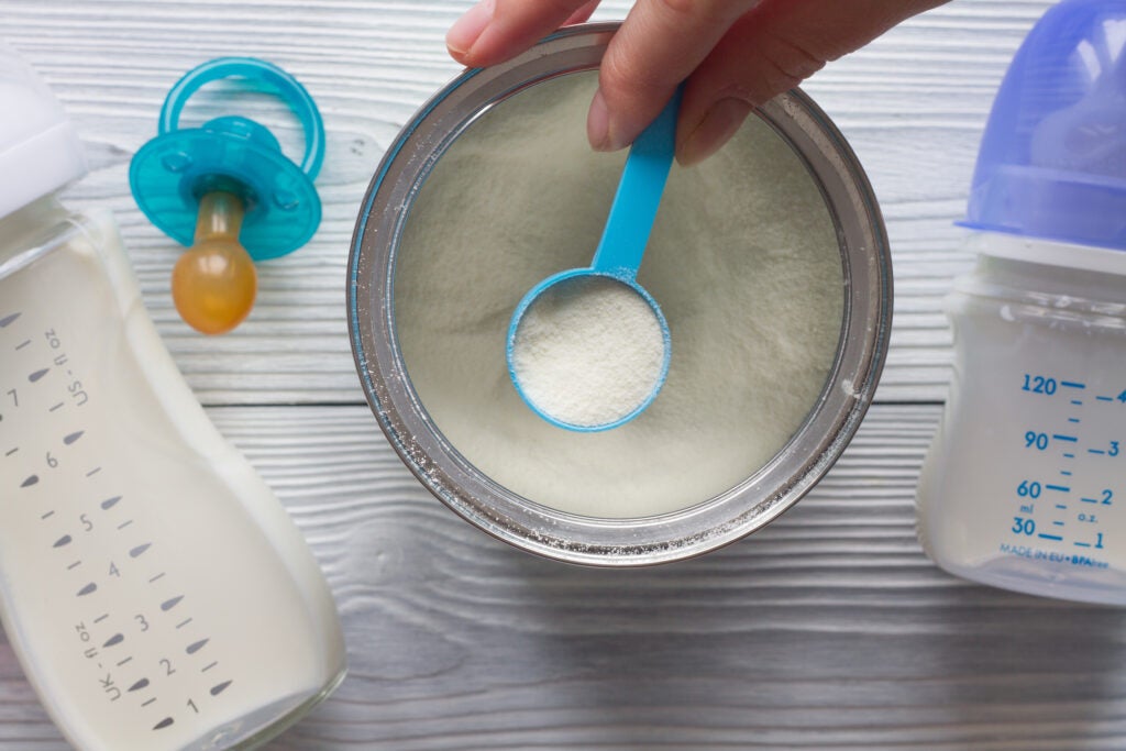 preparation of powdered infant formula with baby bottles on the side