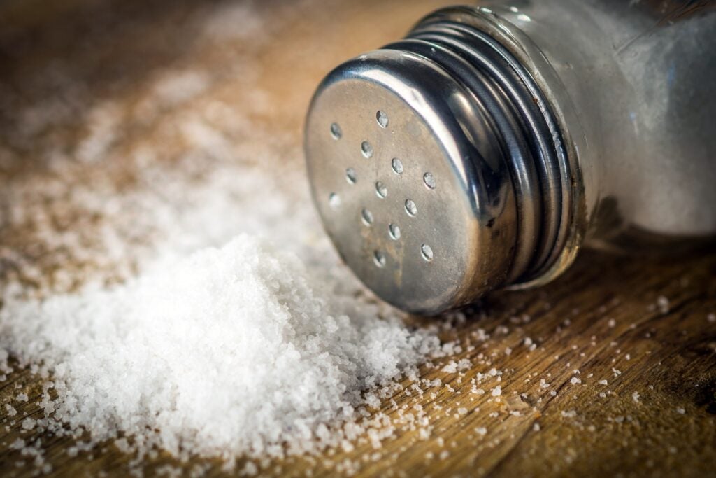 salt shaker on its side with salt crystals spilling out