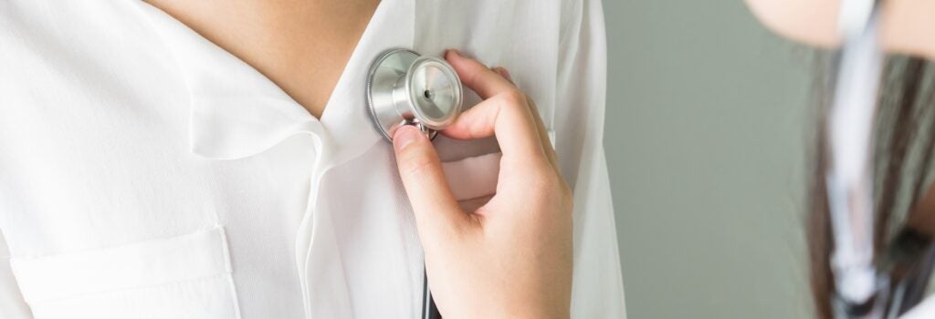 Doctor is using a stethoscope on a patient to hear the heart rate