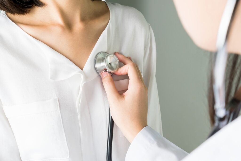 Doctor is using a stethoscope on a patient to hear the heart rate