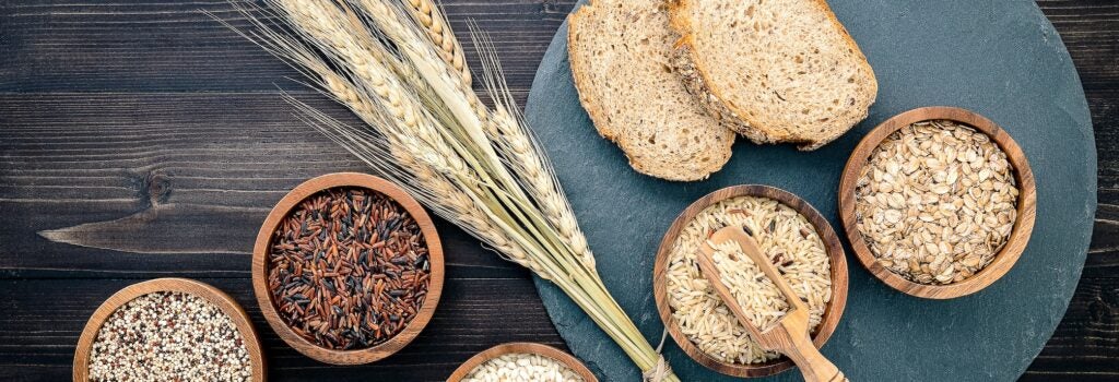 Various natural organic cereal and whole grain seeds in wooden bowls
