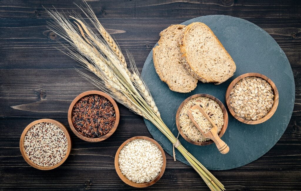 Various natural organic cereal and whole grain seeds in wooden bowls