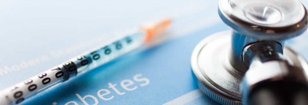 Stethoscope and a syringe on a diabetes test