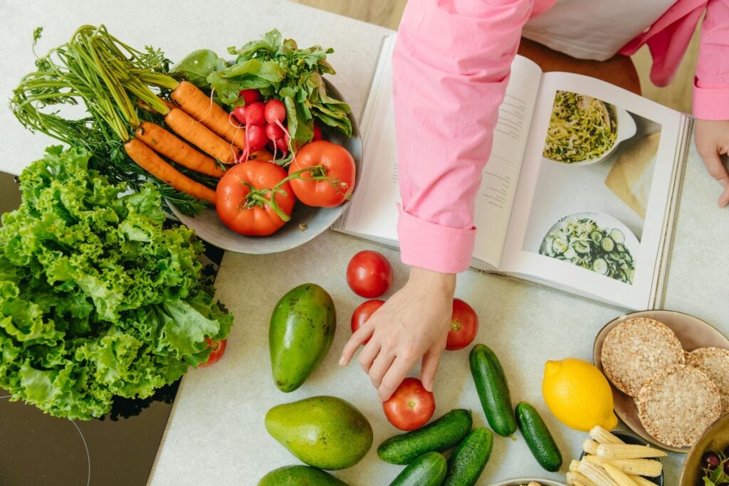 woman's hand with an open receipt book and colorful vegetables