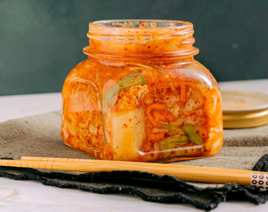 a jar of fermented kimchi with chopsticks